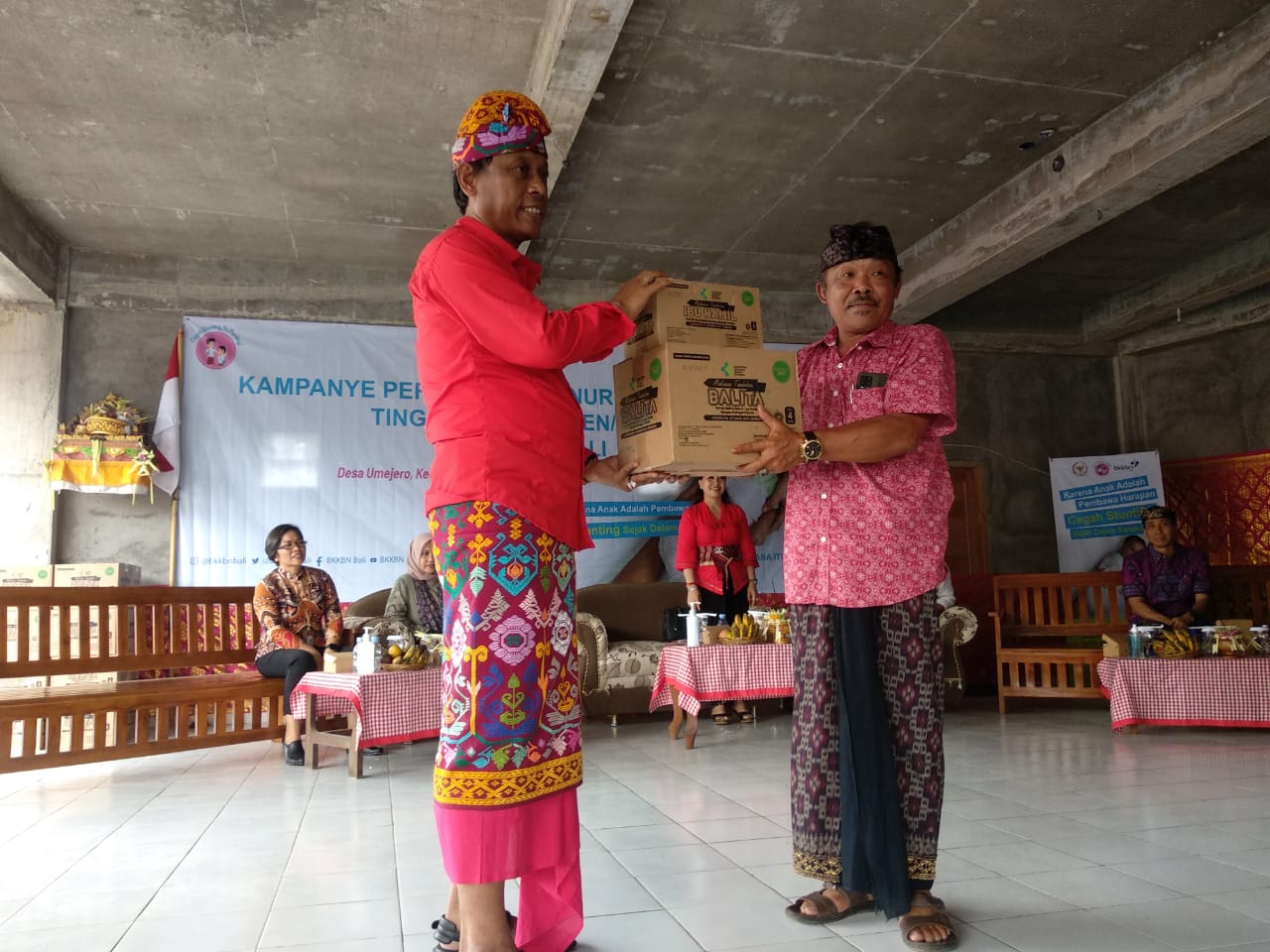 Anggota Komisi IX DPR RI Ketut Kariyasa Adnyana (kiri) saat menyerahkan bantuan biskuit bagi anak dan Ibu Hamil kepada Perbekel Umajero.