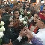 Ketua Pansus TRAP I Made Supartha (udeng merah) saat menerima Bunga Mawar dari Masyarakat Serangan.