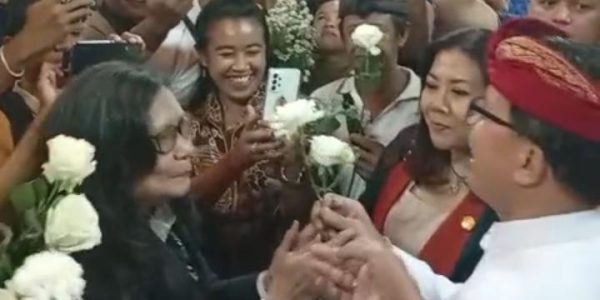 Ketua Pansus TRAP I Made Supartha (udeng merah) saat menerima Bunga Mawar dari Masyarakat Serangan.