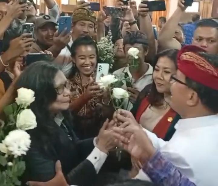 Ketua Pansus TRAP I Made Supartha (udeng merah) saat menerima Bunga Mawar dari Masyarakat Serangan.