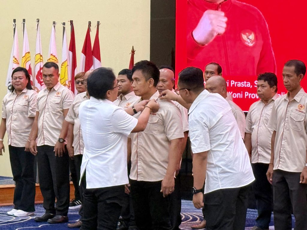 Nyoman Giri Prasta saat memasang Pin kepada Ipat selaku Ketua KONI Jembrama.
