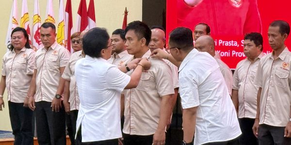 Nyoman Giri Prasta saat memasang Pin kepada Ipat selaku Ketua KONI Jembrama.