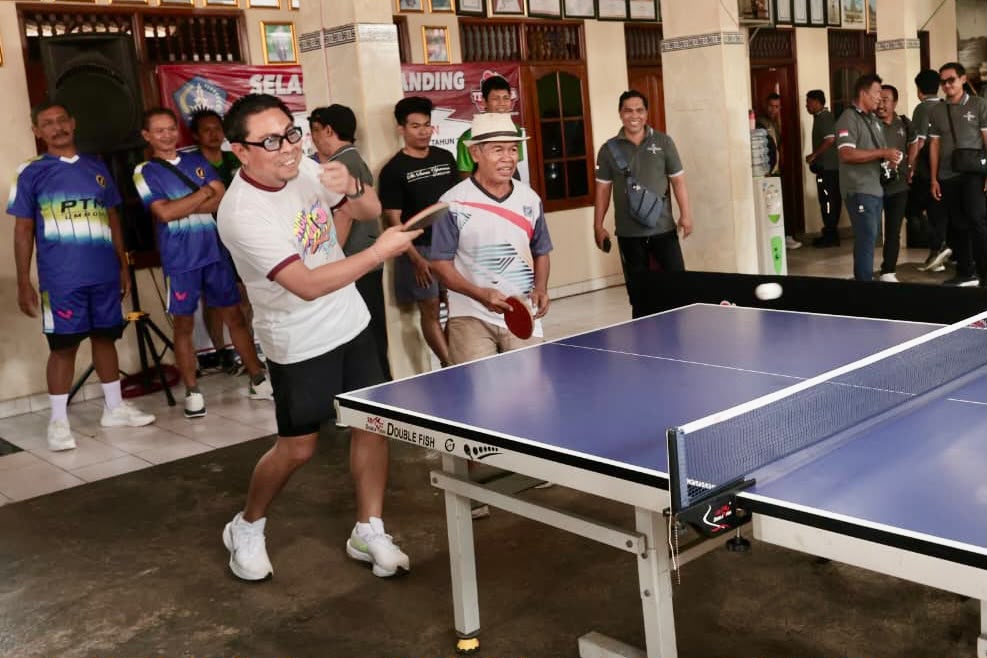 Wawali Arya Wibawa berkesempatan mengawali pertandingan melawan salah seorang peserta pada turnamen Tenis Meja ajang Perbekel Cup IV Desa Padangsambian Kelod di balai Banjar Padangsumbu Kaja, Minggu (7/6).