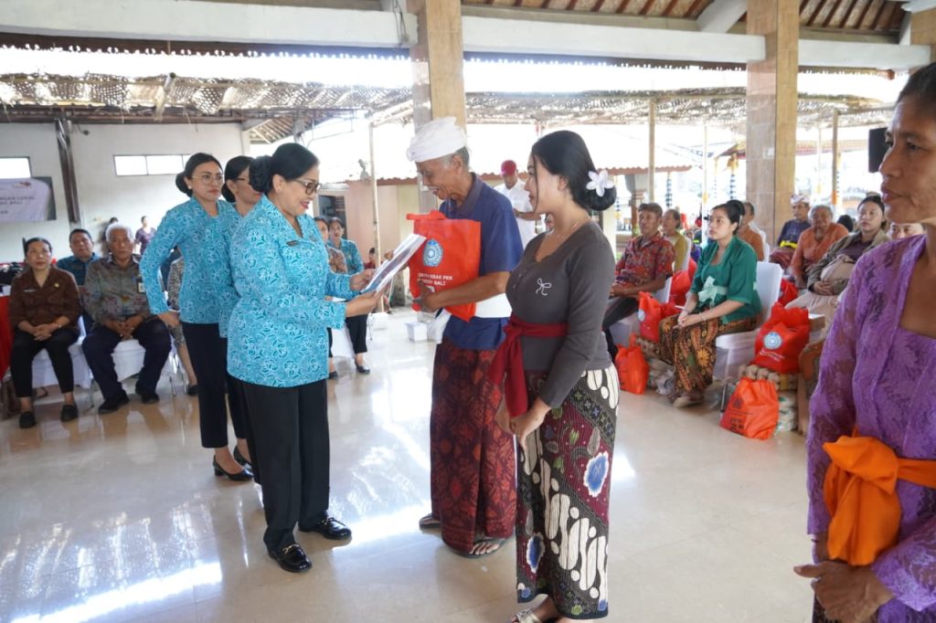 Ketua TP PKK Provinsi Bali, Ny. Putri Koster saat menyerahkan Bantuan kepada Warga di Klungkung.
