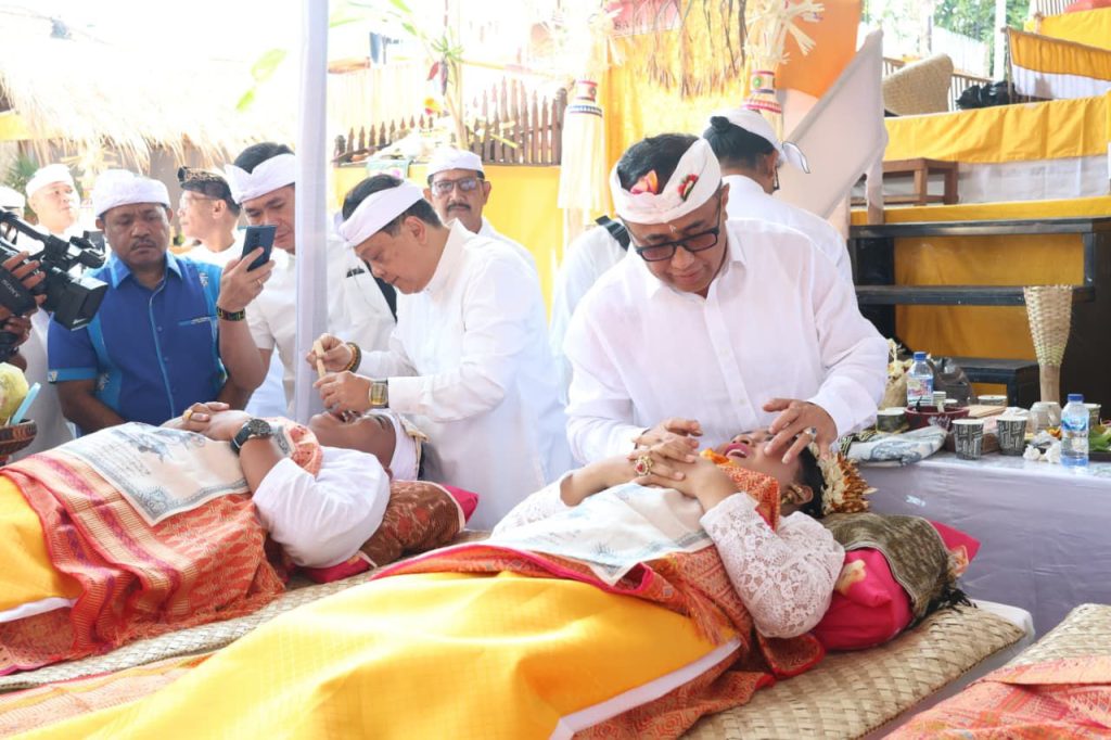 Wali Kota Denpasar, I Gusti Ngurah Jaya Negara saat ngayah nyangging dalam pelaksanaan Upacara Metatah (Mesangih) Massal yang digelar Desa Adat Panjer di Lapangan Wantilan Desa Adat Panjer, Sabtu (29/8).