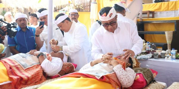 Wali Kota Denpasar, I Gusti Ngurah Jaya Negara saat ngayah nyangging dalam pelaksanaan Upacara Metatah (Mesangih) Massal yang digelar Desa Adat Panjer di Lapangan Wantilan Desa Adat Panjer, Sabtu (29/8).